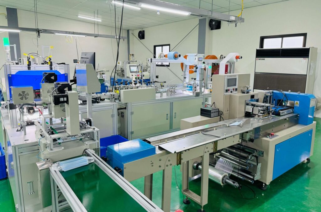 Automated 3-ply surgical face mask assembly and packaging conveyor system inside Makrite manufacturing cleanroom